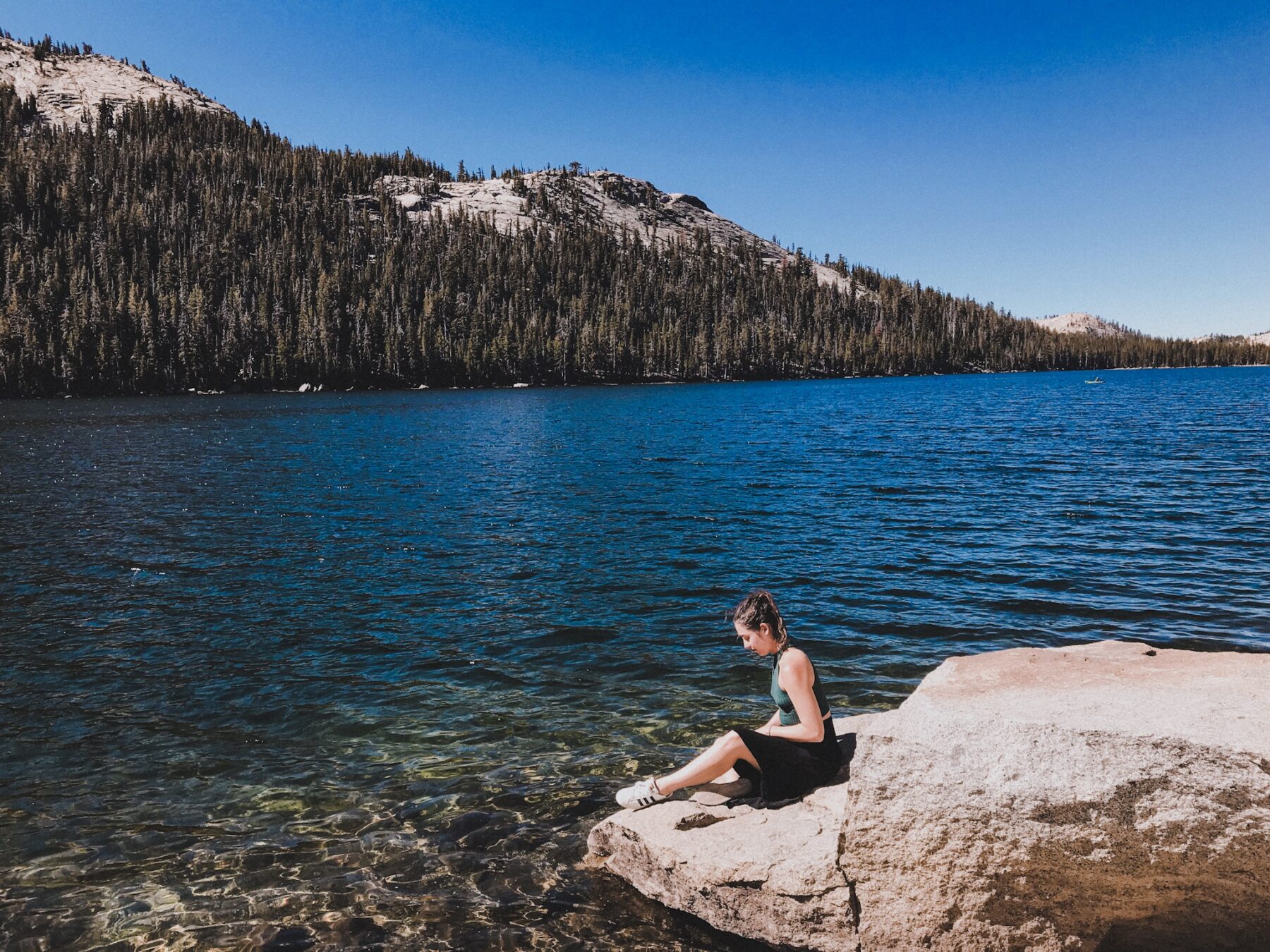 mulher sentada na pedra lago Yosemite California