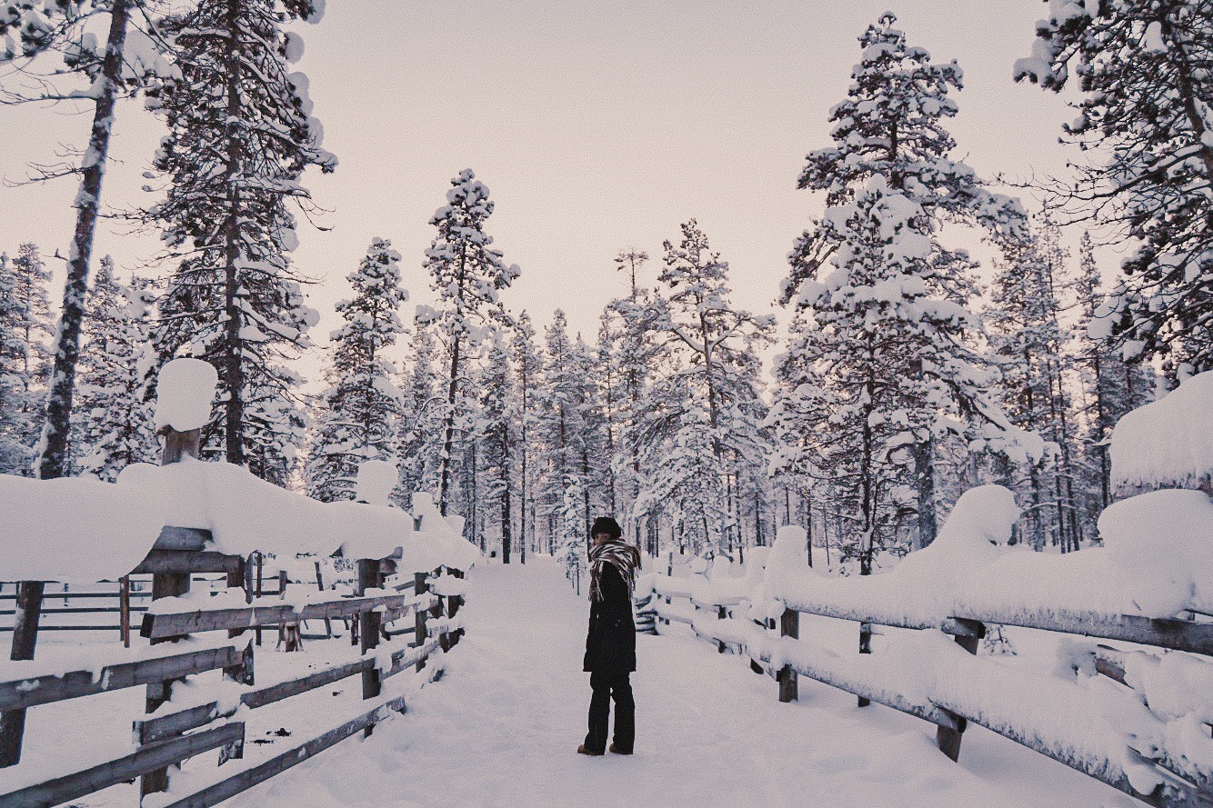 mulher caminha no Inverno coberto de neve hotel Kakslauttanen